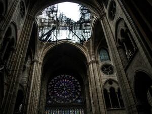 This photo shows one of the rose windows below the damaged roof of Notre-Dame-de Paris Cathedral in Paris on April 16, 2019. (Amaury BLIN / AFP)