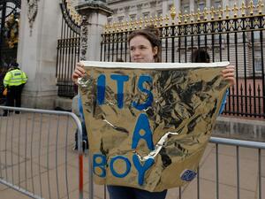 A woman holds a sign that reads "It's a boy" outside the gates of Buckingham Palace in London on May 6, 2019 following the announcement of the birth of a son to Britain's Prince Harry, Duke of Sussex and Meghan, Duchess of Sussex. (AFP/ File)