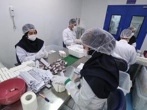 Pharmaceutical factory workers package vitamin and mineral supplement ampoules at the Actoverco plant in Karaj, about 40 kilometres (nearly 25 miles) west of Iran's capital Tehran, on February 18, 2020. ATTA KENARE / AFP