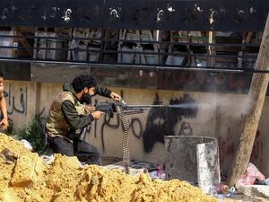 A Libyan fighter loyal to the Government of National Accord (GNA) fires a machine gun during clashes with forces loyal to strongman Khalifa Haftar south of the capital Tripoli's suburb of Ain Zara, on April 10, 2019. (Mahmud TURKIA / AFP)