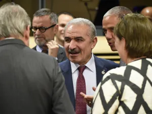 Palestinian Prime Minister Mohammad Shtayeh (C) talks with EU Commissioner for Enlargement Negotiations Johannes Hahn (L). (AFP/ File Photo)