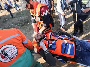 Palestinian paramedics carry a colleague during clashes with Israeli forces following a demonstration by the border fence with Israel, east of Gaza City, on May 3, 3019. (MAHMUD HAMS / AFP)