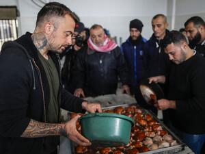 Gabriele Rubini (L), known as Chef Rubio, cooks with Palestinian prisoners at a Hamas-run civilian prison in Gaza City on January 21, 2020, where he is teaching the inmates how to cook Italian food and they teach him Palestinian recipes. MAHMUD HAMS / AFP