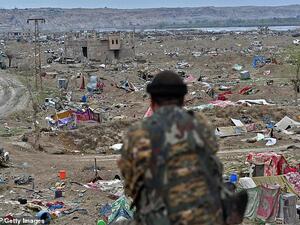 An SDF fighter surveys the bombed-out field below in the remote village of Baghouz close to the Euphrates River in eastern Syria. (AFP/ File PHoto)
