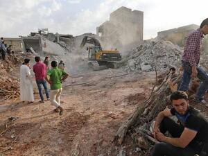 Syrians gather amid destruction in Zardana, in the northern Syrian Idlib province. (AFP/ File Photo)