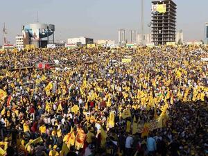Iraqi Kurds wave flags and a poster of Massud Barzani, leader of the Kurdistan Democratic Party (KDP) ahead of a for a parliamentary election. (AFP)