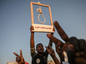 A Sudanese protester holds a hanging rope as others flash victory sign during a protest outside the army headquarters in the capital Khartoum on April 21, 2019. (AFP/ File)