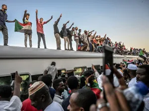 Sudanese protesters from the city of Atbara, flash the V-sign for victory and wave national flags atop a train, as it arrives at the Bahari station in Khartoum on April 23, 2019. (AFP/ File Photo)