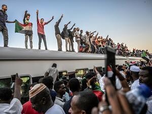 Sudanese protesters from the city of Atbara, flash the V-sign for victory and wave national flags atop a train, as it arrives at the Bahari station in Khartoum on April 23, 2019. (AFP/ File Photo)