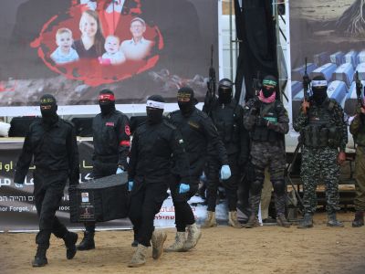 Palestinian militants carry one of the coffins as they hand over the bodies of four Israeli hostages to the Red Cross in Khan Yunis in the southern Gaza on February 20, 2025. Hamas handed over on February 20 coffins believed to contain the bodies of four Israeli hostages, including those of the Bibas family who became symbols of the ordeal that has gripped Israel since the Gaza war began. The transfer of the bodies is the first by Hamas since its October 7, 2023 attack on Israel triggered the war (Photo by Eyad BABA / AFP) Countdown to closure: Israel braces for new hostage remains from Gaza
