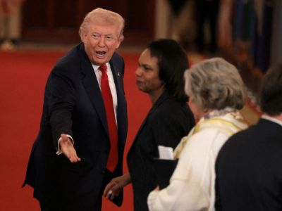  U.S. President Donald Trump speaks to former U.S. Secretary of State Condoleezza Rice