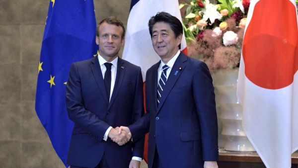  France's President Emmanuel Macron (L) shakes hands with Japan's Prime Minister Shinzo Abe prior to the Japan-France summit at Abe's official residence in Tokyo on June 26, 2019.