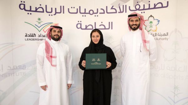 Lina Khaled Almaeena, center, the co-founder of Jeddah United Sports Co. (JUSC), receives a certificate from an official of the General Sports Authority.