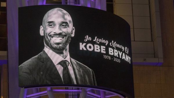 Memorial signage hangs near people mourning for former NBA star Kobe Bryant, who was killed in a helicopter crash in Calabasas, California.