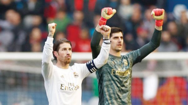 صورة لكورتوا يحتفل مع سيرخيو راموس قائد الفريق بالفوز عقب نهاية مباراة أوساسونا