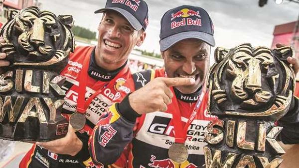 Qatar’s ace rally driver Nasser al-Attiyah (right) and his co-driver Mathieu Baumel of France celebrate after winning the Silk Way Rally in Dunhuang, China, on July 16, 2019 (Photo: Gulf Times)