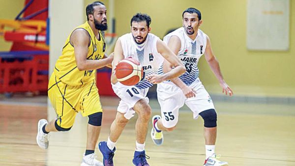 Al-Jahra player (left), shoots as Al-Sahel players defend during the Group 1 competitions of the Kuwait Basketball League Championship 2020-2021 season. (Photo: Arab Times)