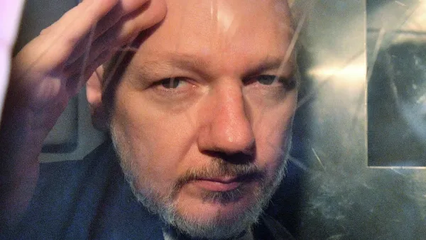 WikiLeaks founder Julian Assange gestures from the window of a prison van as he is driven out of Southwark Crown Court in London. (AFP/ File Photo)