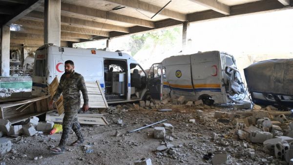 A Syrian government soldier walks past destroyed ambulances and vehicles of the Syrian Civil Defence, also known as "The White Helmets" at their captured former headquarters in the town of Qalaat al-Madiq, some 45 kilometres northwest of the central city of Hama, on May 17, 2019. (AFP/ File)