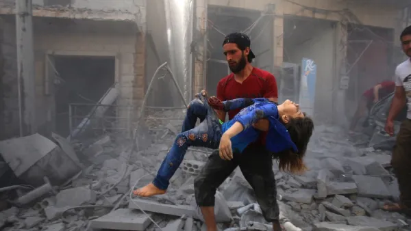 A man evacuates a young bombing casualty after a reported air strike by regime forces and their allies in the jihadist-held Syrian town of Maaret Al-Noman in the southern Idlib province, on May 26, 2019. (Abdulaziz KETAZ / AFP)