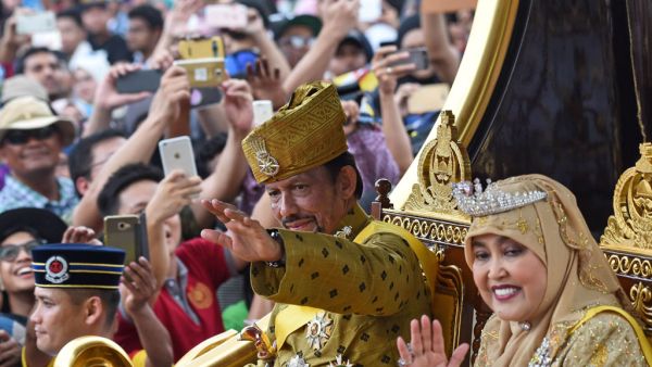 Brunei’s Sultan Hassanal Bolkiah and Queen Saleha ride in a royal chariot during a procession. (AFP/ File Photo)