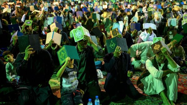 Afghan Shiite Muslim worshippers hold copies of the holy Quran as they pray during the Laylat al-Qadr at a mosque in Herat province. (HOSHANG HASHIMI / AFP)