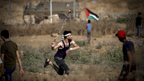 A Palestinian man hurls a stone during clashes with Israeli forces near the fence along the border with Israel near Bureij in the central Gaza Strip on June 14, 2019. (MOHAMMED ABED / AFP)