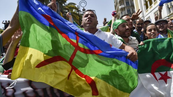 Algerian protesters wave the Amazigh (C) and national flags as they chant slogans during the weekly Friday demonstration in the capital Algiers on June 21, 2019. (AFP/ File Photo)