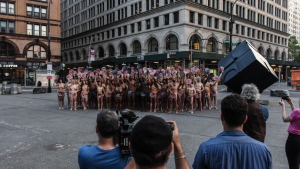 People are directed by artist Spencer Tunick to pose nude holding cut outs of nipples during a photo shoot on June 2, 2019 in New York City. Spencer Tunick staged his photo shoot in front of the Facebook building in Manhattan to protest Facebook and Instagram's ban on showing the female nipple. (AFP)