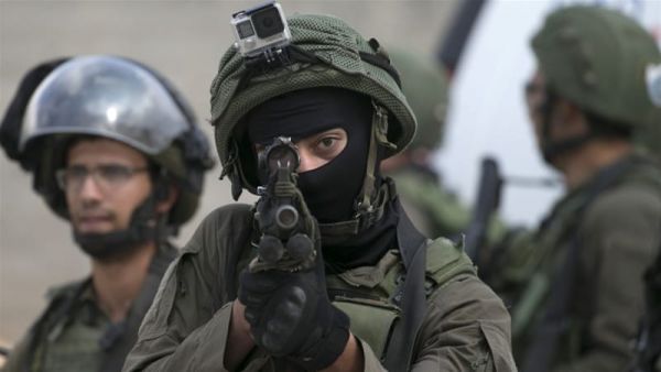 Israeli soldier aims his weapon at Palestinians. [Jaafar Ashtiyeh/AFP/Getty Images]