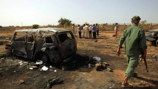Libyans inspect the site of a car bomb attack that targeted servicemen during the funeral of an ex-army commander in the Libyan city of Benghazi (AFP)