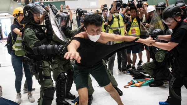 Police officers tear the shirt of a protester during a clash inside a shopping arcade in Sha Tin of Hong Kong after a rally against a controversial extradition law proposal in Sha Tin district of Hong Kong on July 14, 2019. (AFP/ File Photo)
