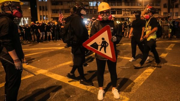 A protester holds a road sign as a shield following a march against a controversial extradition bill in Hong Kong on July 21, 2019. (VIVEK PRAKASH / AFP)