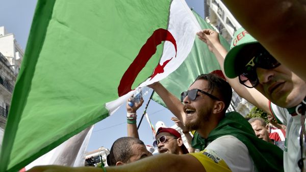A man waves an Algerian national flag as protesters demonstrate in Algiers  (AFP)