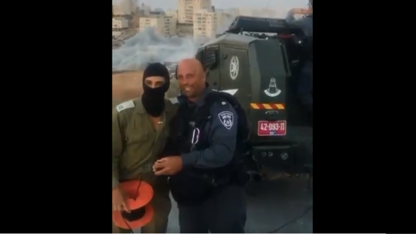 Israeli soldiers and police cheer the demolition of scores of Palestinian homes. (Twitter/ Screenshot)