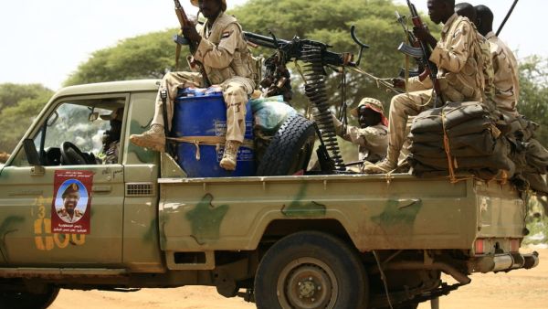 Sudanese members of the Rapid Support Forces, a paramilitary force backed by the Sudanese government to fight rebels and guard the Sudan-Libya border, ride in the back of a Toyota pickup truck. (AFP/ File Photo)