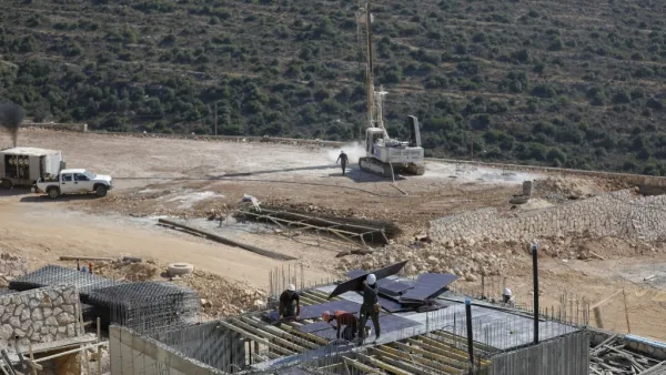 Palestinian labourers work at a construction site in the Israeli settlement  (AFP)
