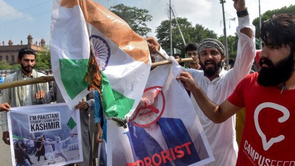 Students of Islami Jamiat-e-Talaba (IJT), a wing of religious political party Pakistan Jamaat-e-Islami (JI), burn a photograph of Indian Prime Minister Narendra Modi and an Indian flag during a protest in Lahore on August 7, 2019. (AFP)