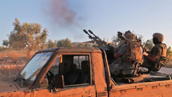 Fighters from the former al-Qaeda Syrian affiliate Hayat Tahrir al-Sham (HTS) fire an anti-aircraft gun mounted on a pickup truck in Syria's southern Idlib province on August 7, 2019. (Omar HAJ KADOUR / AFP)