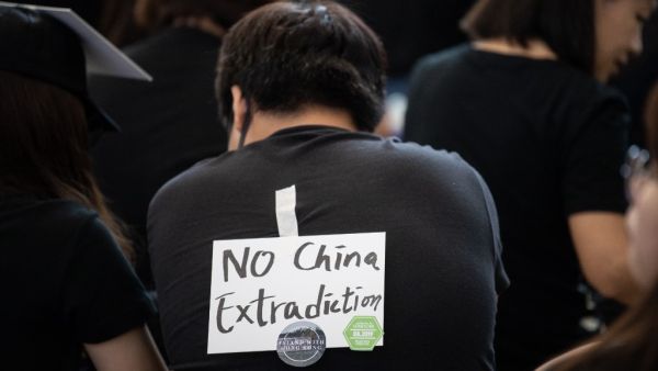 A protester wears a note on the back of his T-shirt as he takes part in a rally against a controversial extradition bill at Hong Kong's international airport (AFP)