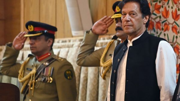Pakistan's Prime Minister Imran Khan (R) listens to the national anthem as he arrives at the legislative assembly in Muzaffarabad. (AFP/ File Photo)