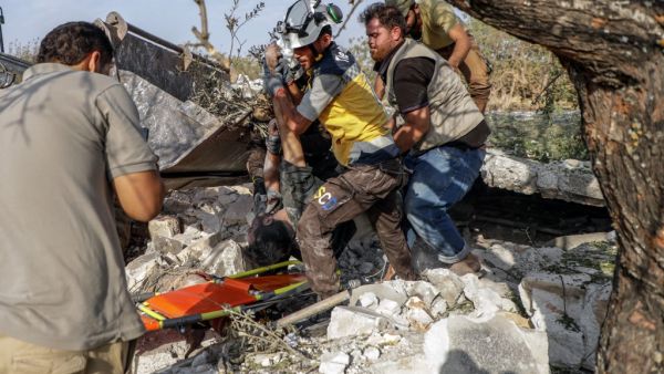 Syrians and members of Syrian Civil Defence recover a body from the rubble after a reported airstrike by regime planes on the town of Maaret Hurmah in the southern countryside of Syria's northwestern Idlib province, on August 14, 2019. (Abdullah Hammam / AFP)