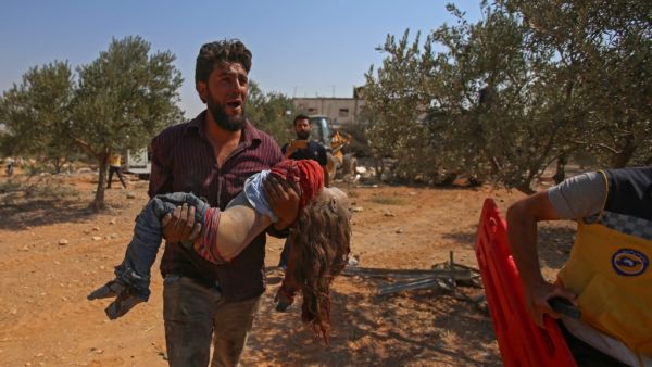 A Syrian carries the body of a child at the site of a reported regime air strike on the village of Deir Sharqi on the eastern outskirts of Maaret al-Numan in Syria's northern province of Idlib on August 17, 2019. (AFP/ File Photo)