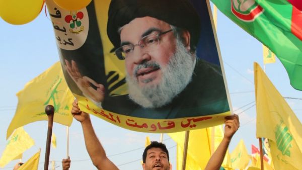 Supporters of the Lebanese Shiite Hezbollah movement carry ballons, party flags and a photograph of the movement's leader Hasan Nasrallah, in the town of Al-Ain in Lebanon's Bekaa valley on August 25, 2019. (AFP/ File Photo)