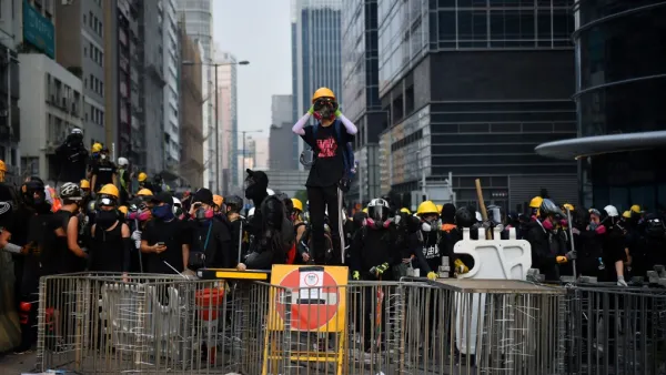 Protesters face off with riot police at Kowloon Bay in Hong Kong on August 24, 2019, in the latest opposition to a planned extradition law that has since morphed into a wider call for democratic rights in the semi-autonomous city. (AFP)