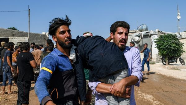 Men carry away a child amidst clashes between displaced Syrians and the Turkish gendarmerie following a demonstration (AFP)