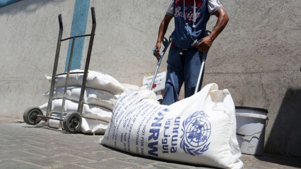 Palestinians receive their monthly food aid at a United Nations distribution center. (Shutterstock/ File Photo)