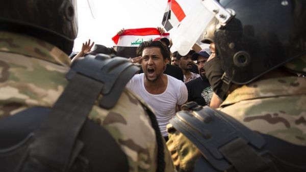 An Iraqi protestor gestures in front of security forces during a demonstration against state corruption, failing public services and unemployment, on October 2, 2019 in the southern city of Basra. (AFP/ File Photo)