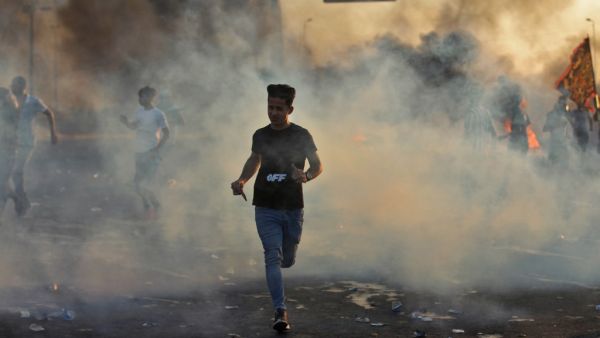 Iraqi demonstrators run amidst smoke from burning tyres during a demonstration against state corruption, failing public services, and unemployment, in the Iraqi capital Baghdad on October 5, 2019. (AFP/ File Photo)
