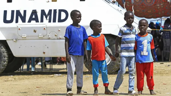 Displaced Sudanese boys pose for a picture in front of a UN-African Union mission to Darfur (UNAMID) vehicle at the Kalma camp for internally displaced people in Darfur's state capital Niyala on October 9, 2019. (AFP/ File)